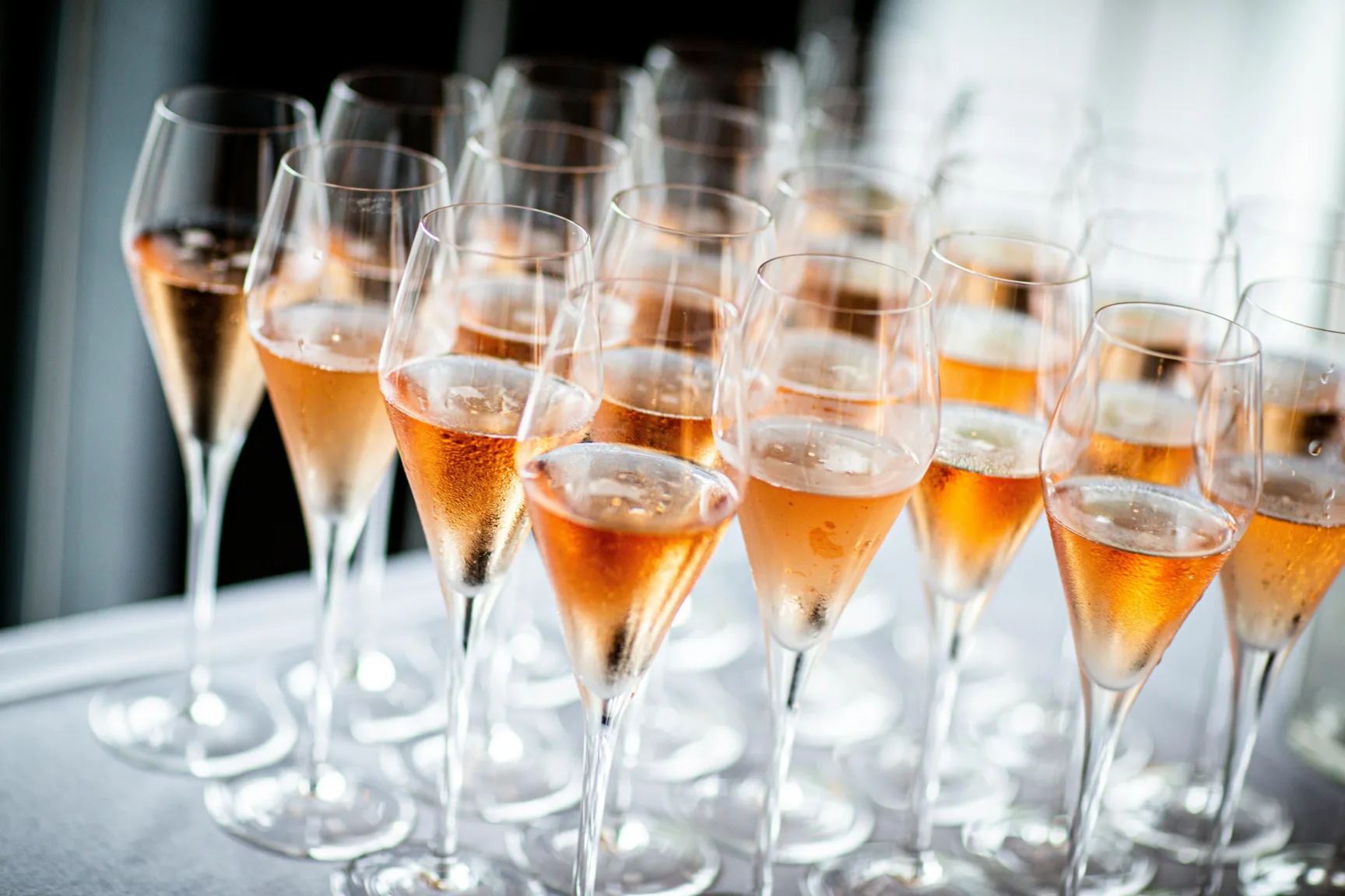 Champagne glasses filled with sparkling wine on a white table