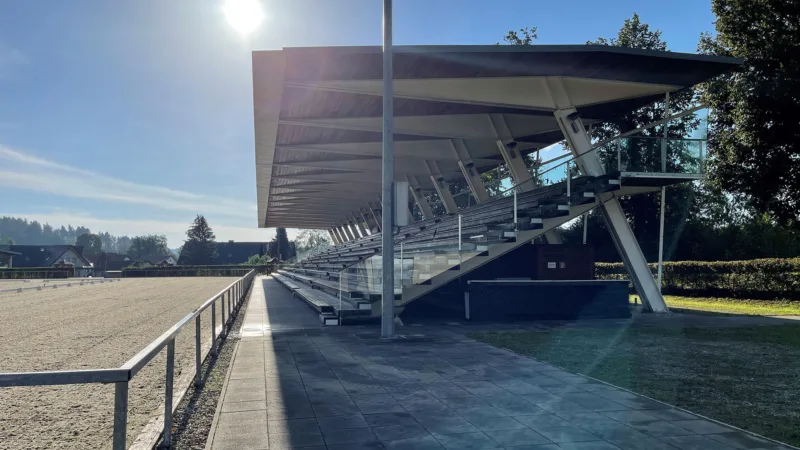 Horse arena with grandstand seating in the sunshine